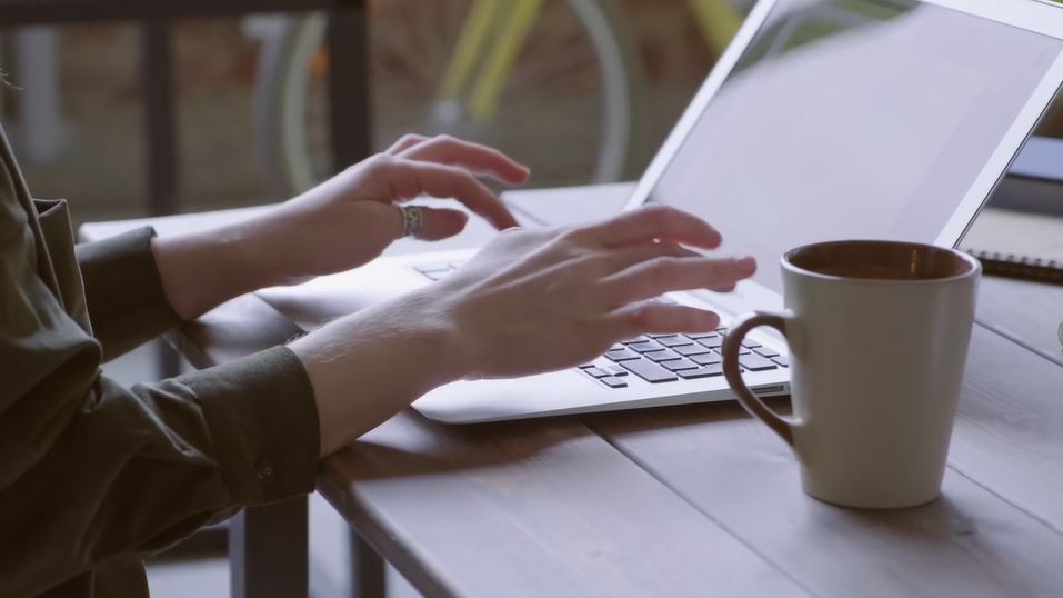 Image of person typing on laptop full size