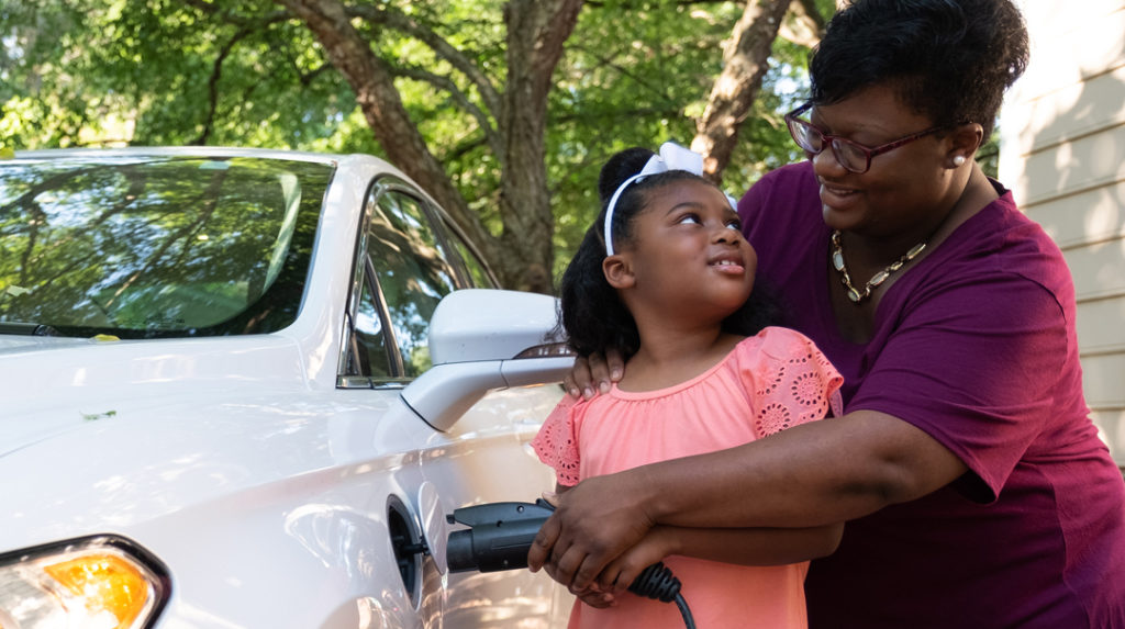 Mom helping daughter plug in EV