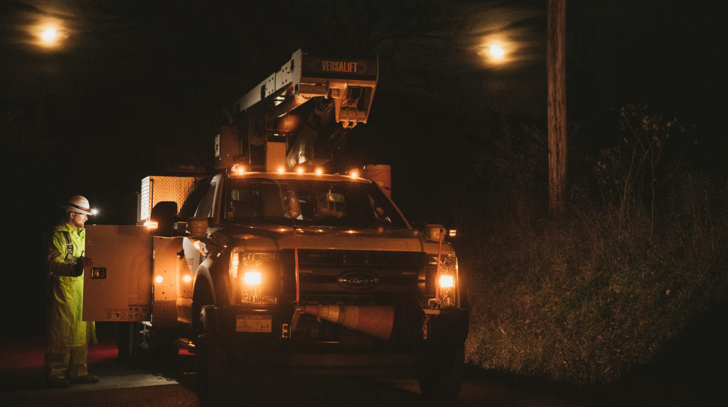 Lineworker and truck working in the dark.