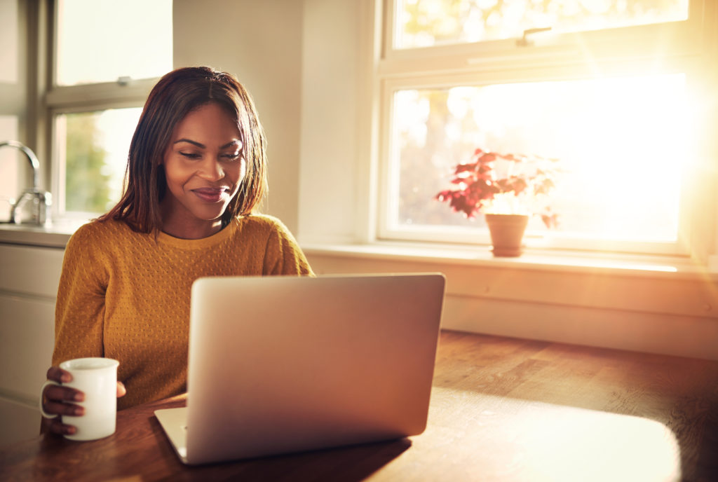 Woman working from home on laptop at table